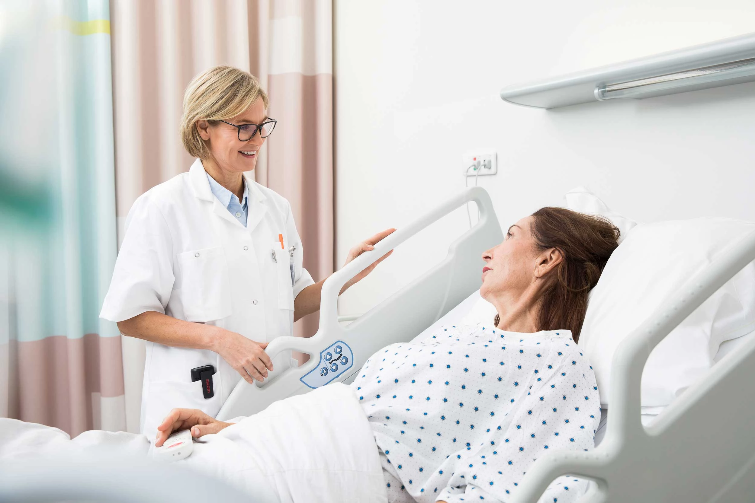Caregiver and patient with nurse call in hospital 