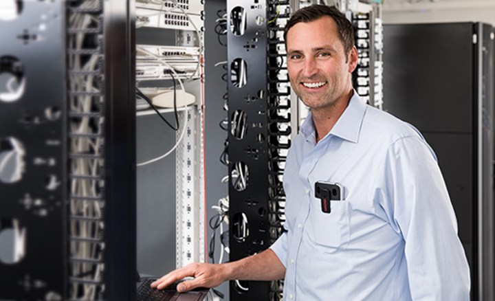 IT technician in server room working on laptop i63 clip showing from the chest pocket