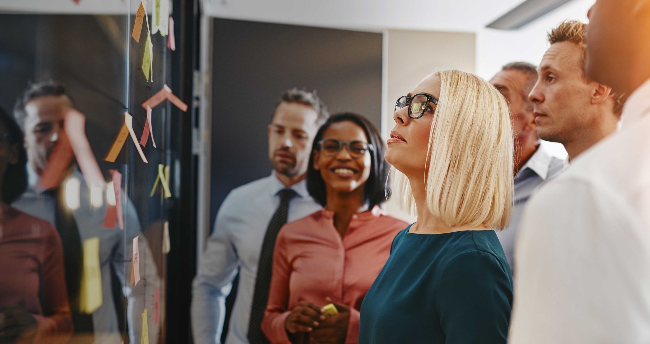 Diversity team in a project meeting with sticky notes on a whiteboard