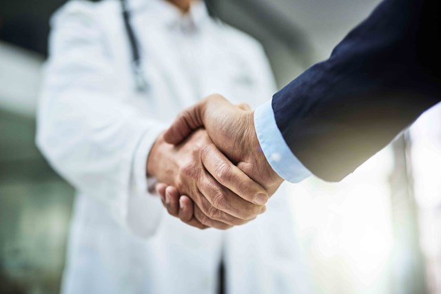 A doctor and man shaking hands