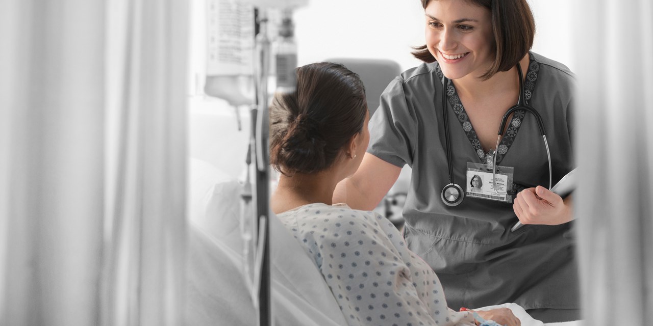 Female caregiver interacting with female patient in a hospital room
